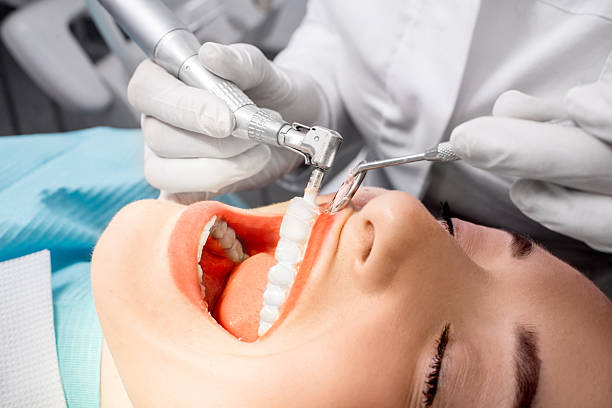 Teeth cleaning Dentist making professional teeth cleaning female young patient at the dental office. Close-up plan